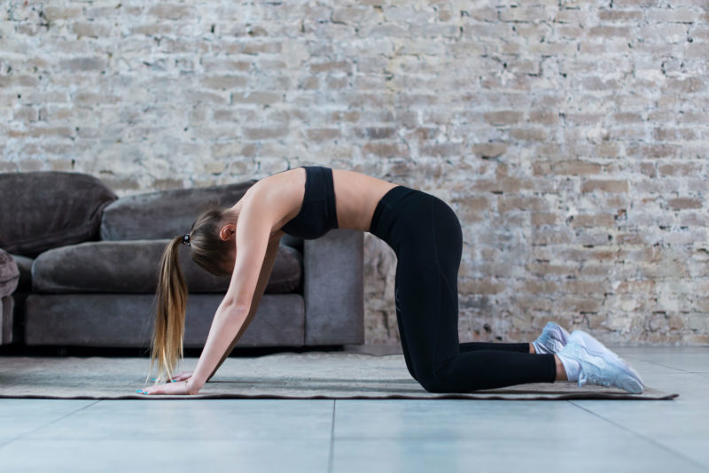 Young woman doing stretches for lower back pain