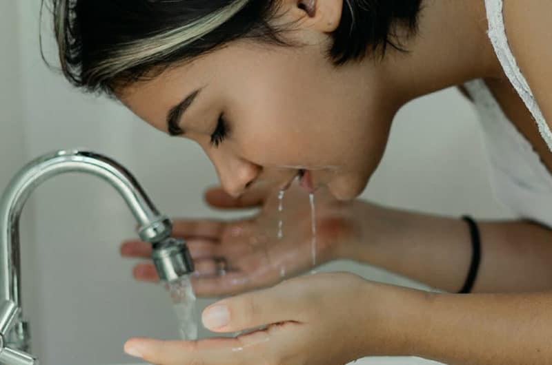 girl washing her face and keeping skin clean